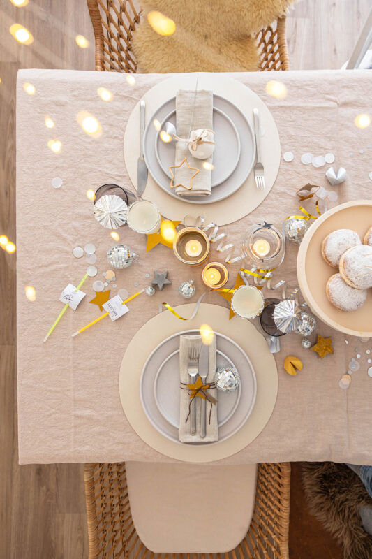 Tischdeko für Silvester mit Konfetti und Luftschlangen in gold und silber